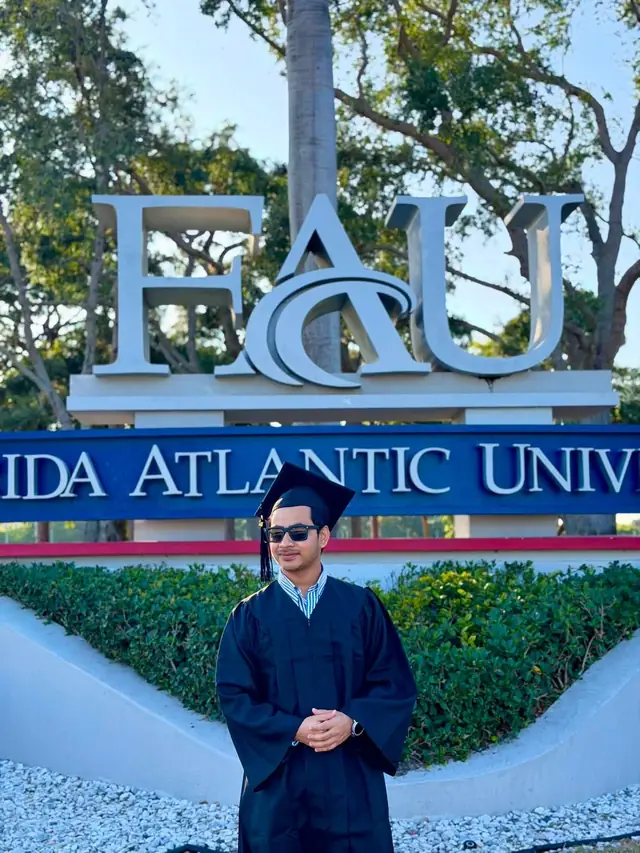 Naim Bin Hasan in his graduation gown at the Florida Atlantic University sign in Boca Raton.