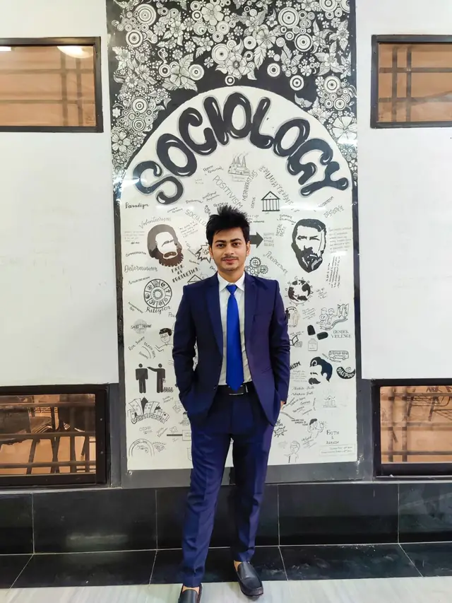 Naim Bin Hasan in front of the sociology mural at the University of Dhaka.