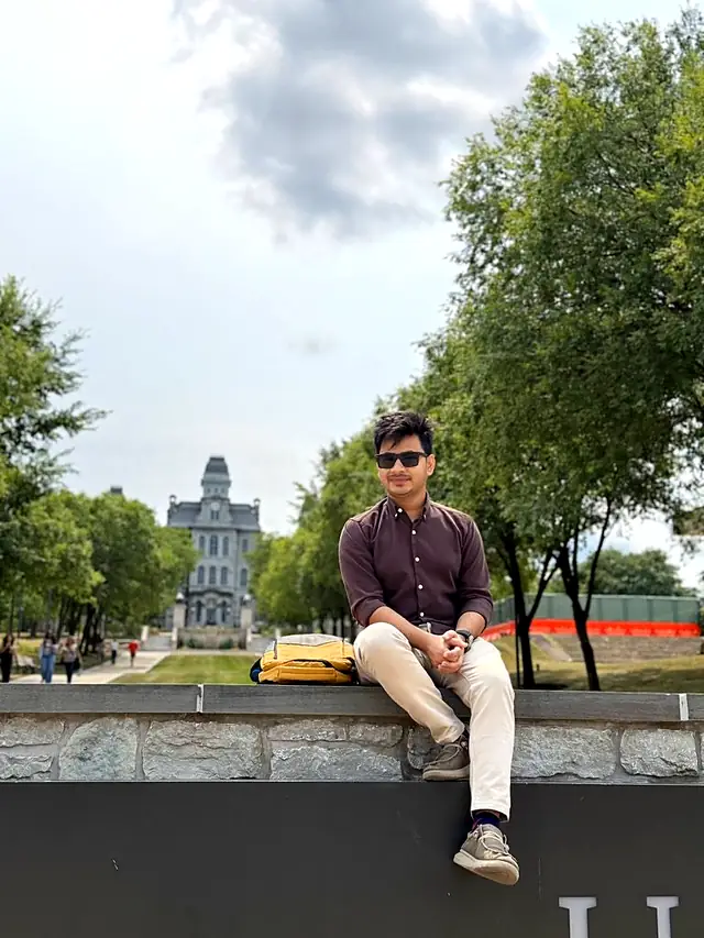 Naim Bin Hasan on the Syracuse University campus, with the Hall of Languages in the background.